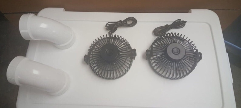 May include: Two black electric fans with white cords and white plastic connectors. The fans are on a white surface.