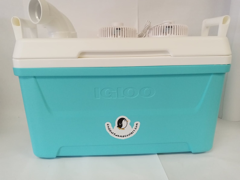 May include: A blue Igloo cooler with a white lid and two fans on top. The cooler has a sticker on the front that says "Chillout Swamp Coolers.com".
