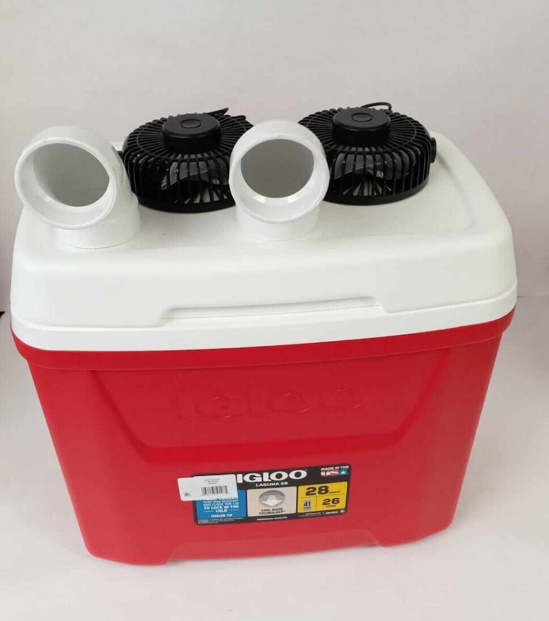 May include: Red Igloo cooler with two fans attached to the top. The cooler has a white lid and a yellow label that says "Igloo Laguna 28" and "Made in the USA".