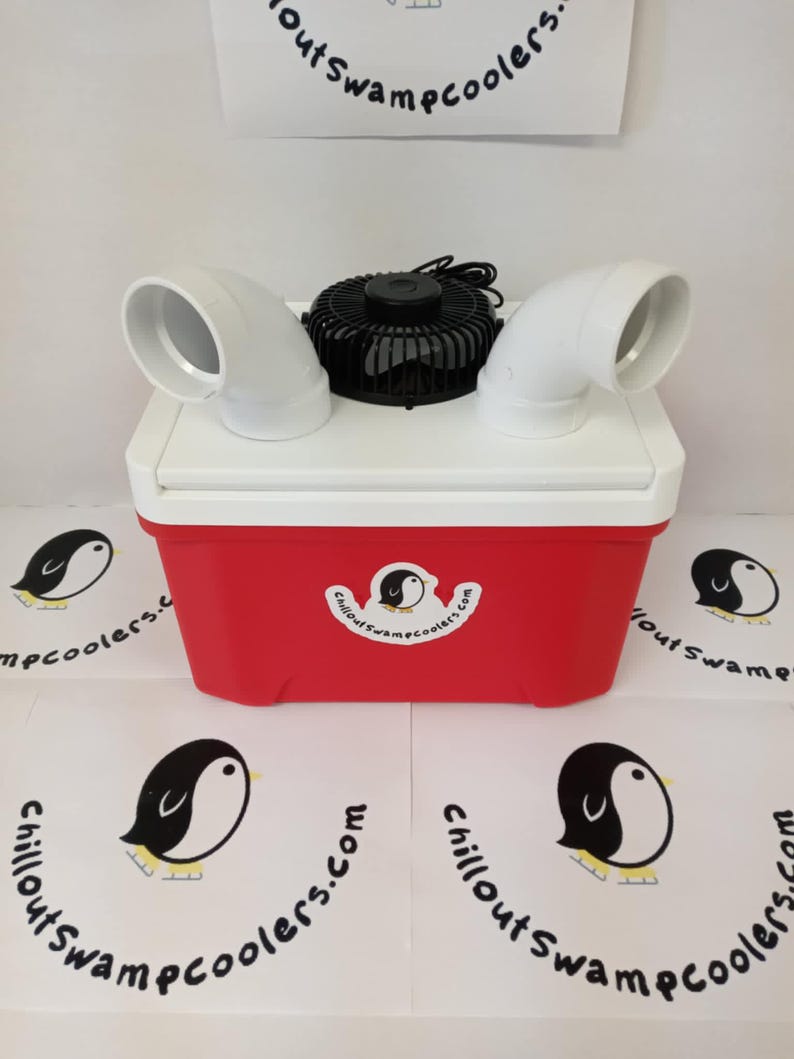 May include: A red and white cooler with a black fan and white air vents. The cooler has a penguin logo and the text "Chillout Swamp Coolers.com". The logo is repeated on the surface around the cooler.