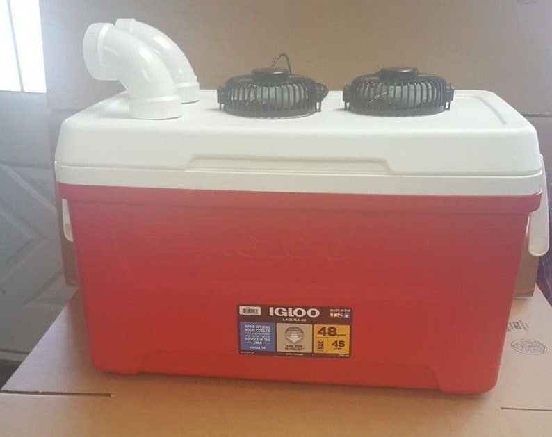 May include: Red Igloo cooler with two black fans on top and white PVC pipes on the side. The cooler has a white lid and a sticker that says "Igloo Leisure 48 QT" with the numbers "48" and "45" circled.
