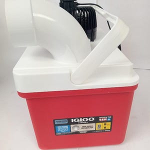 May include: A red and white Igloo Laguna 5 cooler with a white handle and a black motor attached. The cooler has a white top and a red base. The cooler is 13 inches long, 9 inches wide, and 8 inches high.