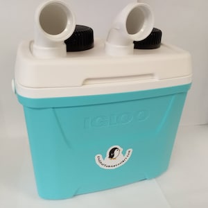 Pode incluir: Uma caixa t&eacute;rmica Igloo turquesa com duas bicas de pl&aacute;stico branco no topo. A caixa t&eacute;rmica tem um logotipo de pinguim preto e branco com o texto "igloocoolers.com".