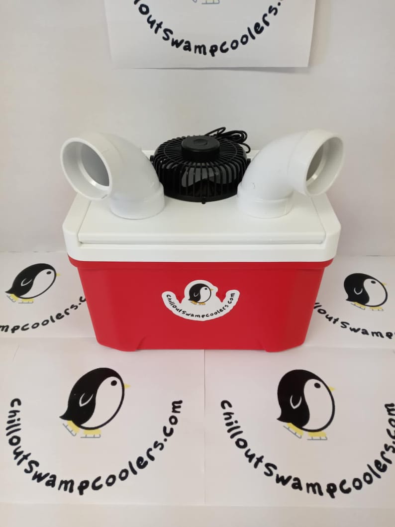 May include: A red and white cooler with a black fan and white air vents. The cooler has a logo with a penguin and the text "Chillout Swamp Coolers.com". The image also shows the logo repeated on the surface.