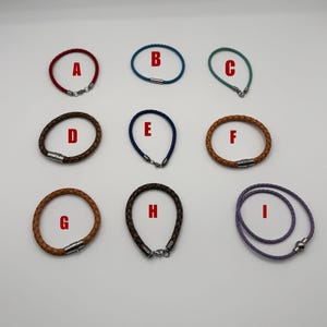 May include: Nine braided leather bracelets in various colors, including red, blue, green, brown, and purple. Each bracelet has a metal clasp. The bracelets are labeled A through I.