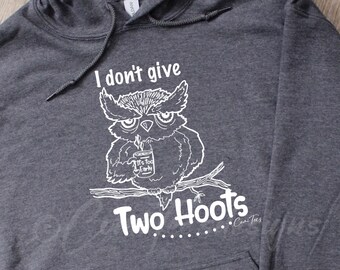 May include: A gray hoodie with a white graphic of an owl holding a mug that says "It's Too Early". The text "I don't give two hoots" is below the owl. The text "...Cowl Tees" is below the graphic.