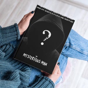 以下が含まれることがあります： 「The Mysterious Man」というタイトルの黒い本。フード付きの人物と疑問符の白黒画像。本の表紙には「Some stories arrive with secrets that can change everything.」という引用も含まれています。