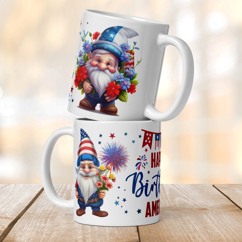 Op de afbeelding: Twee witte keramische mokken met een patriottisch thema. De bovenste mok heeft een gnome die een rood, wit en blauwe hoed draagt en een boeket bloemen vasthoudt. De onderste mok heeft een gnome die een rood, wit en blauwe hoed draagt en een boeket bloemen en vuurwerk vasthoudt. De tekst op de onderste mok is "Happy Birthday America".