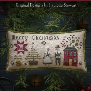 May include: A cross-stitch sampler with the text "Merry Christmas" and a winter scene with a house, a tree, and two figures. The sampler is on a dark background with green pine branches and red berries.