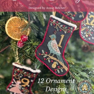 May include: Twelve Days of Christmas Stockings cross stitch pattern set.  Each stocking features a different design, including a bird, a dancer, and a bell.  The pattern is designed by Annie Beez.  12 Ornament Designs.