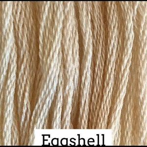 May include: A close-up of a bundle of cream-colored embroidery floss. The floss is tightly wound and has a slightly textured surface. The text "Eggshell" is visible at the bottom of the image.