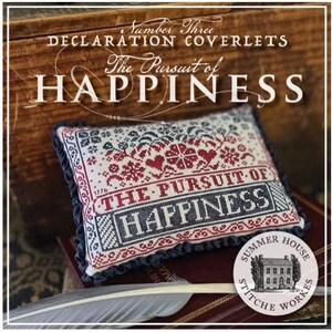 May include: A rectangular decorative pillow featuring cross-stitch embroidery with the text "THE PURSUIT OF HAPPINESS" in red and dark blue thread on a cream fabric. The pillow is finished with a dark blue ruffled edge and intricate floral motifs.