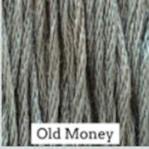 May include: Close-up of a skein of yarn in a muted green color with a subtle blue undertone. The yarn is labeled "Old Money".