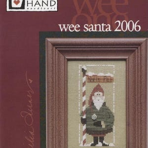 May include: Wee Santa 2006 cross stitch pattern by Cecilia Downer. The pattern features a small Santa Claus standing next to a sign that reads "North Pole".