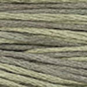 May include: A close-up of a textured, green and gray yarn. The yarn is made of natural fibers and has a rustic look.