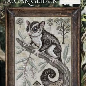 May include: Cross-stitch of a sugar glider perched on a branch, framed in a dark wood. The artwork features the text "A Year in the Woods II #2" and "The Sugar Glider". The Cottage Garden Samplings logo is in the upper right corner.