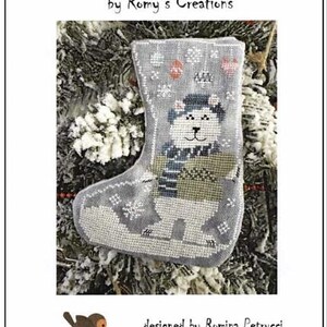 May include: A gray Christmas stocking with a polar bear design. The stocking features a polar bear wearing a hat and scarf, with snowflakes and the text "POLAR BEAR" at the top. The design is by Romy's Creations.