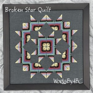 May include: A framed cross-stitch pattern of a "Broken Star Quilt" with a colorful geometric design. The frame is black and the background is gray. The text "WorksByABC" is in the bottom right corner.