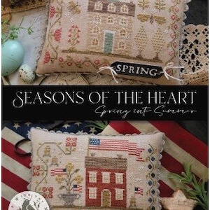 May include: Two decorative cross-stitch pillows with house designs. One pillow has a tag that says "SPRING", the other says "SUMMER". The pillows are part of the "Seasons of the Heart" collection.