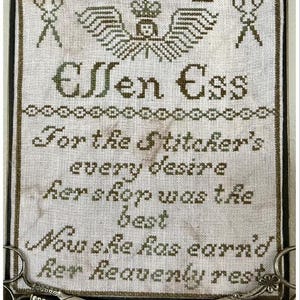May include: A framed sampler with green embroidery on white fabric. The sampler reads "Ellen Ess For the Stitcher's every desire her shop was the best Now she has earn'd her heavenly rest".