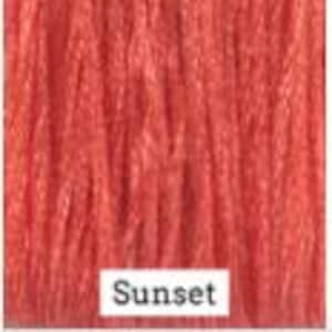 May include: A close-up of a wood stain sample in a vibrant sunset orange color. The word "Sunset" is printed below the sample.