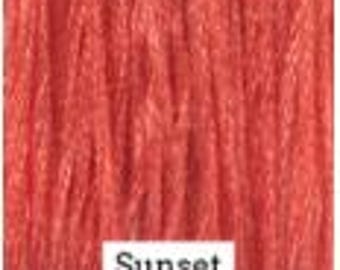 May include: A close-up of a wood stain sample in a vibrant sunset orange color. The word "Sunset" is printed below the sample.