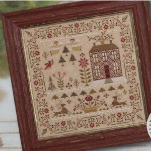 May include: A framed cross-stitch design titled "The Light of Winter" by Brenda Gervais. The design features a winter scene with a house, trees, birds, and a deer. The design is in a red frame with a gold border.