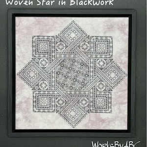 May include: Framed blackwork embroidery featuring a geometric star design. The artwork, titled "Woven Star in Blackwork," showcases intricate patterns in black thread on a light pink fabric. The piece is framed in a black square frame. The artist's name, "WorksByABC," is visible.