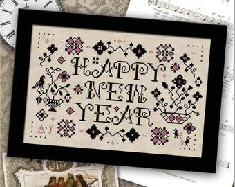 May include: A framed cross-stitch design with the words "HAPPY NEW YEAR" in black, accented with pink floral motifs. The image includes a vintage clock, sheet music, and a postcard with birds.
