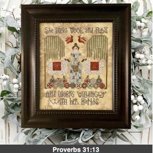 May include: A framed cross-stitch embroidery with the text "She seeks wool and flax and works willingly with her hands" and the Bible verse "Proverbs 31:13". The embroidery depicts a woman standing between two sheep, with a red bird on each side.