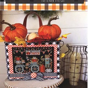 May include: A cross-stitch pattern featuring a black and white checkered basket filled with pumpkins and a cross-stitch design of a pumpkin patch with a bicycle and a scarecrow. The text "Let's Go Ride a Bike" and "Pumpkin Patch" are visible on the image.