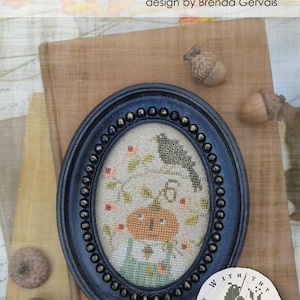 May include: An oval black frame with a beaded edge containing a cross-stitch embroidery of a pumpkin character, a bird, and the number 6. The text at the top reads #CS383 Pixie Pics JACK O. LANTERN design by Brenda Gervais.