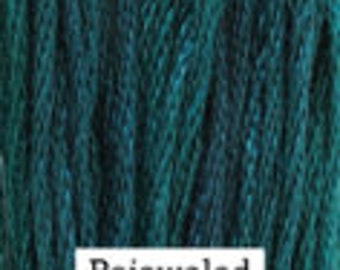 May include: Close-up of a skein of teal-colored yarn. The yarn is tightly wound and has a textured appearance. The word "Bejeweled" is printed in a white rectangle at the bottom of the image. The yarn appears to be made of a soft material.