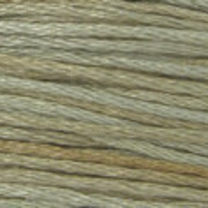 May include: A close-up of a spool of beige and light gray embroidery floss.