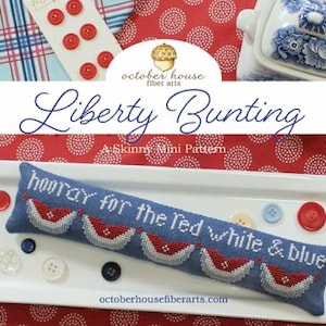 May include: A patriotic-themed display featuring a blue banner embroidered with "hooray for the red white & blue." The banner is on a white tray with buttons and a blue and white patterned dish. The text "Liberty Bunting" is also visible.