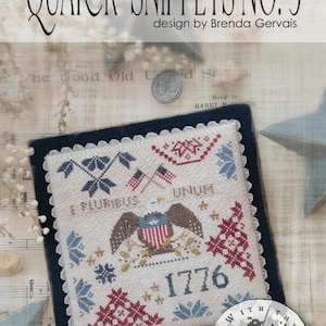 May include: A cross-stitch sampler titled "Quaker Snippets No. 3" by Brenda Gervais. The design features an eagle, flags, and the year 1776, with the text "E PLURIBUS UNUM." The sampler is framed with a dark blue border and lace trim.