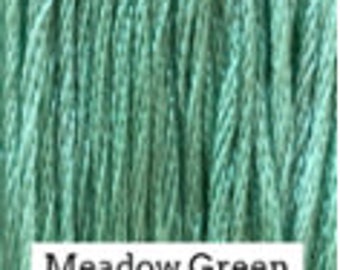 May include: Close-up of a spool of light green embroidery floss. The floss is smooth and shiny, and the color is a bright, vibrant green.