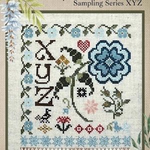 May include: Cross-stitch sampler featuring a floral alphabet design. The sampler includes the letters X, Y, and Z, surrounded by flowers and decorative borders in shades of blue, pink, and brown. The text "Floral Alphabet" is at the top.