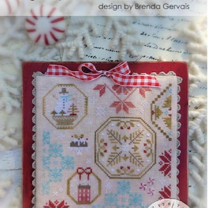 May include: A framed cross-stitch sampler titled "Quaker Snippets No. 2" by Brenda Gervais. The sampler features various geometric and floral patterns in red, gold, blue, and white. A red and white checkered ribbon adorns the top. The design includes the text "#CS366".