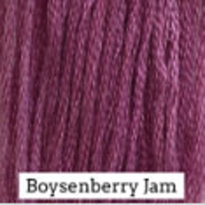 May include: Close-up of a deep purple yarn with the text "Boysenberry Jam" printed on the bottom.