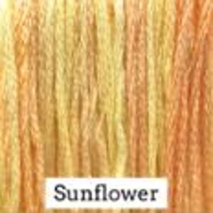 May include: A close-up of a skein of yarn in shades of yellow, orange, and brown. The yarn is labeled "Sunflower".