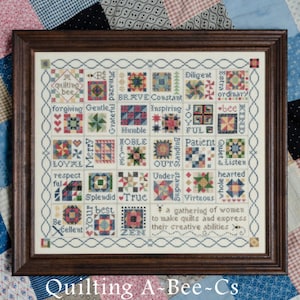 May include: Framed cross-stitch sampler with a brown wooden frame. The sampler features colorful squares with words like "brave," "gentle," and "zen." The text "XYZ ~ Part 5" is at the top. The words "Quilting A-Bee-Cs" are at the bottom.