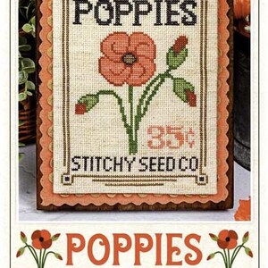 May include: Cross-stitch kit featuring a poppy design. The image shows a framed cross-stitch with the word "POPPIES" at the top, a central poppy flower, and the text "STITCHY SEED CO." at the bottom. The kit is part of the "Seed Packet Cross Stitch Series."
