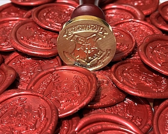 May include: A gold-toned wax seal stamp with the Hogwarts crest and the words "Hogwarts School of Witchcraft and Wizardry" around the crest. The stamp is surrounded by red wax seals.