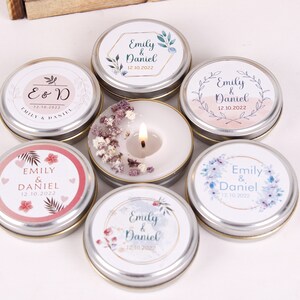 Peut inclure: Six petites bo&icirc;tes rondes en &eacute;tain avec couvercles, chacune pr&eacute;sentant un motif floral diff&eacute;rent et le texte "Emily & Daniel" avec une date de mariage. Les couvercles sont argent&eacute;s avec une bordure dor&eacute;e.