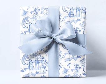 May include: A white gift box with a blue and white floral pattern and a blue satin ribbon tied in a bow.