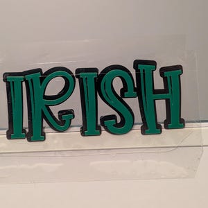 May include: Green and black vinyl letters spelling out the word "IRISH".
