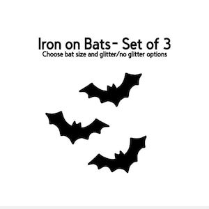 May include: Three black bat iron-on transfers on a white background. The text reads "Iron on Bats - Set of 3" and "Choose bat size and glitter/no glitter options". These are ideal for Halloween or themed crafts.