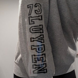 May include: Gray sweatshirt with a black iron-on design that says "NEW YORK" and the numbers "73" on the sleeve.