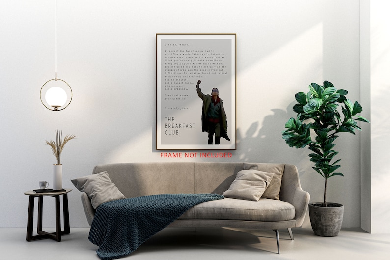 May include: A minimalist poster featuring a black and white image of a man raising his fist in the air. The poster has a gray background and the text "The Breakfast Club" in black. The text "FRAME NOT INCLUDED" is printed in red at the bottom of the poster.